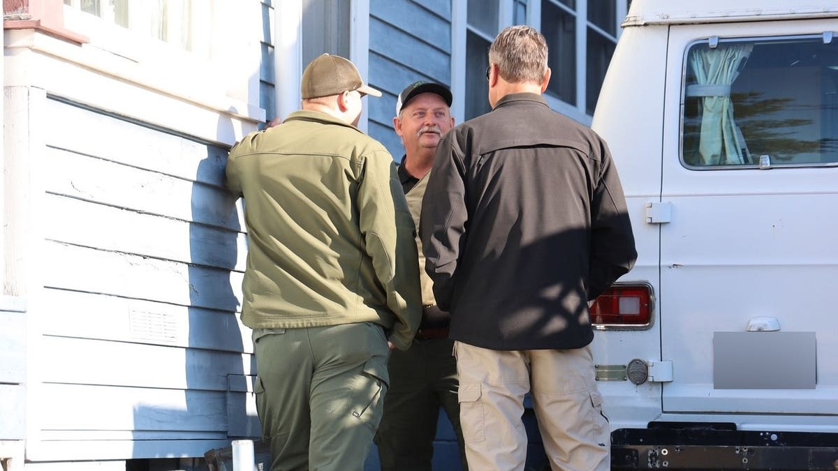Investigators outside a home