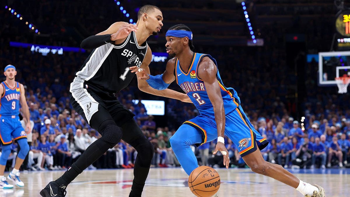 Shai Gilgeous-Alexander driving to basket against Victor Wembanyama during NBA Western Conference Finals