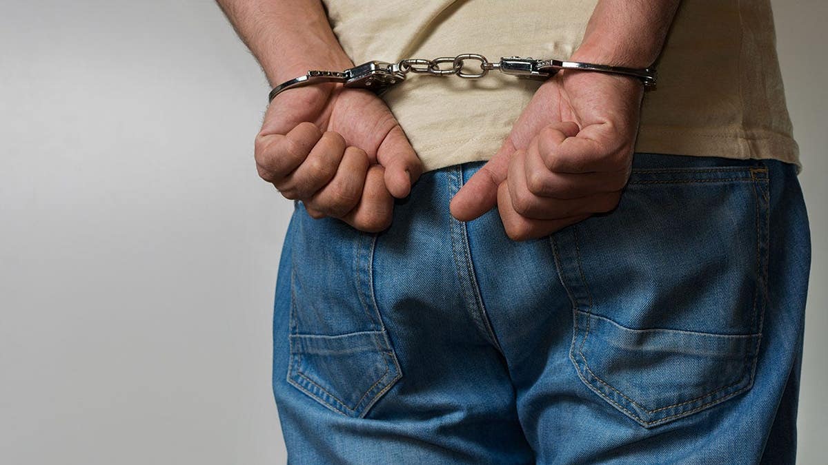 Adult male handcuffed and standing