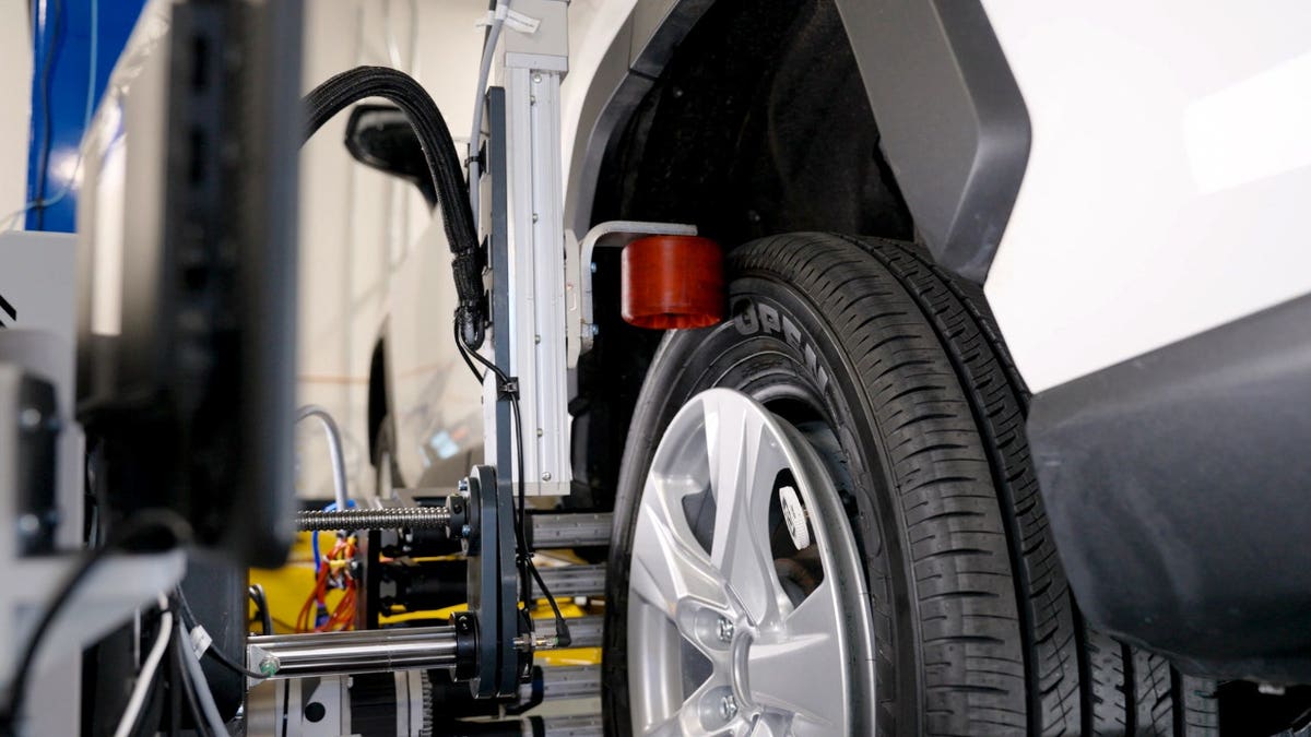 A car tire is shown next to a robotic system.