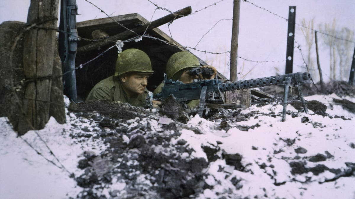 Airborne infantrymen operating a .30-caliber machine gun in a snowy battlefield