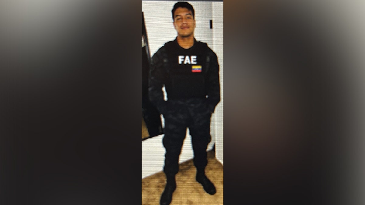 Un hombre vestido con un uniforme negro en el que se leen las letras «FAE»