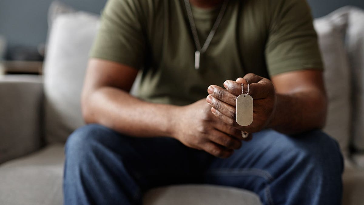 army veteran holding dog tags necklace during therapy session