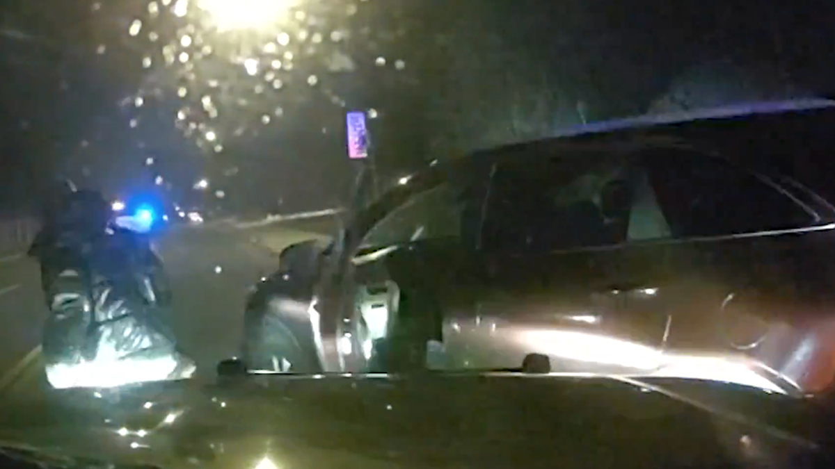 Un agente de policía de Aurora se acerca a un vehículo robado tras una maniobra PIT durante una persecución nocturna