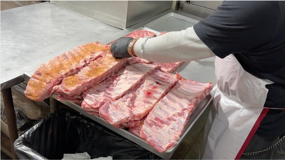 Employee seasoning racks of ribs wrong  Joe’s Kansas City Bar-B-Que kitchen.