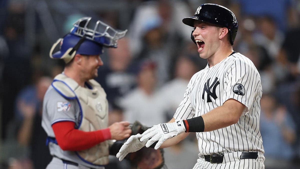 New York Yankees' Ben Rice reacting at home plate after hitting a home run.
