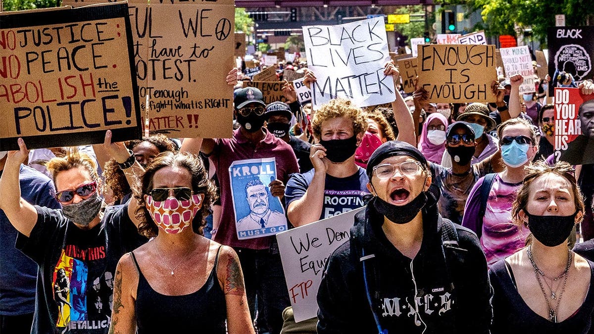 Manifestantes marcham perto da delegacia de polícia de Minneapolis durante manifestação.
