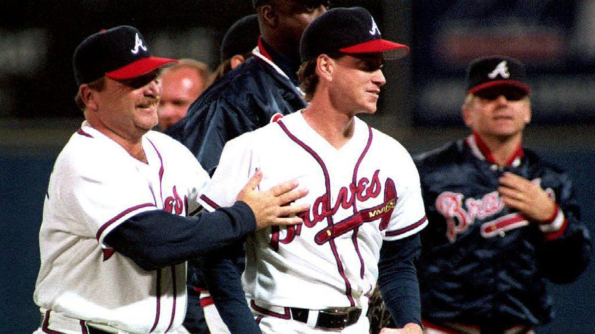 Atlanta Braves-manager Bobby Cox feliciteert werper Tom Glavine met het veld
