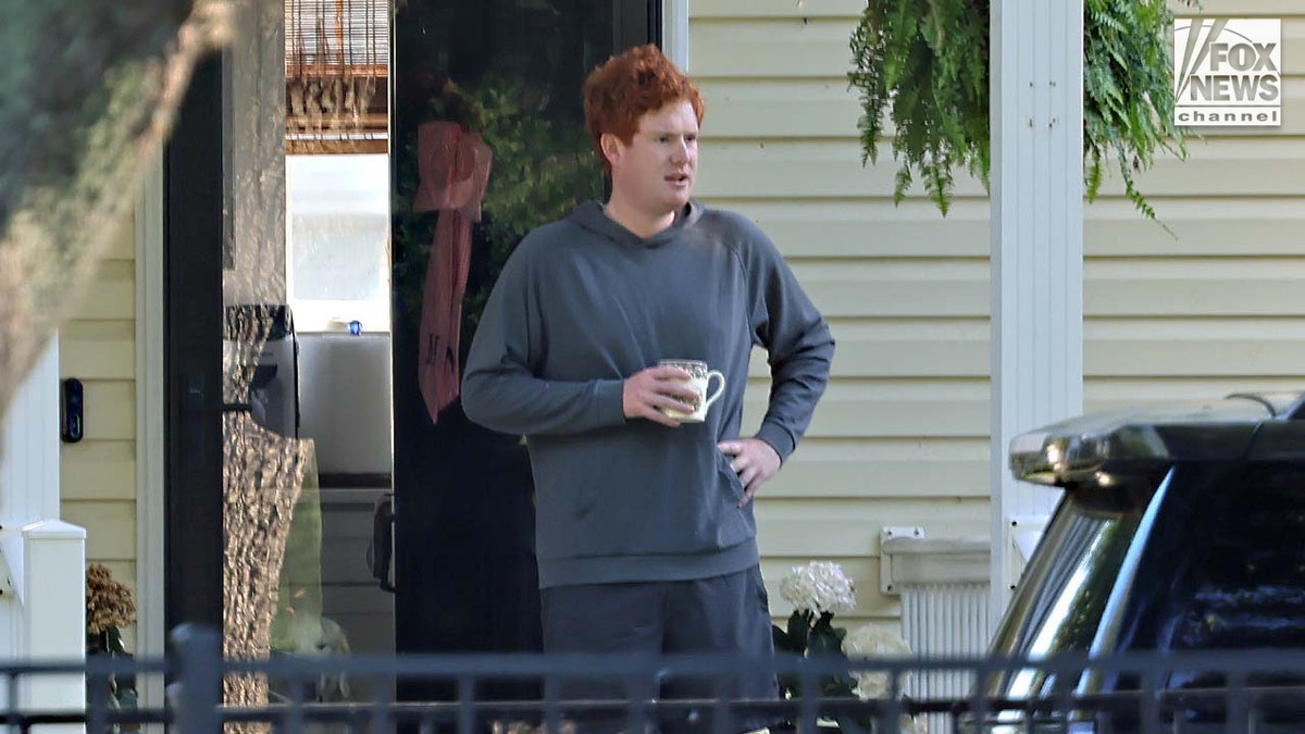 Buster Murdaugh sits connected  the beforehand   structure  of a location  portion    holding a java  cup.