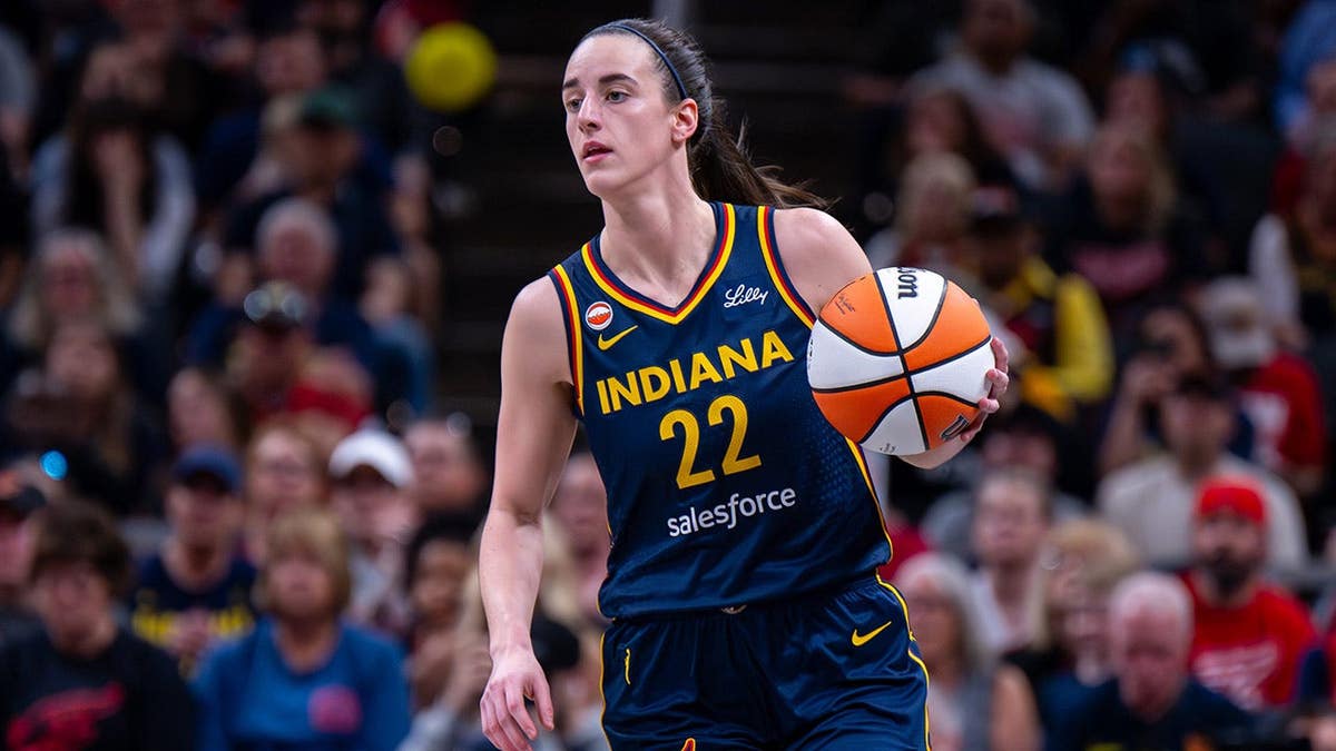 Caitlin Clark, guarda do Indiana Fever, driblando basquete durante jogo no Gainbridge Fieldhouse