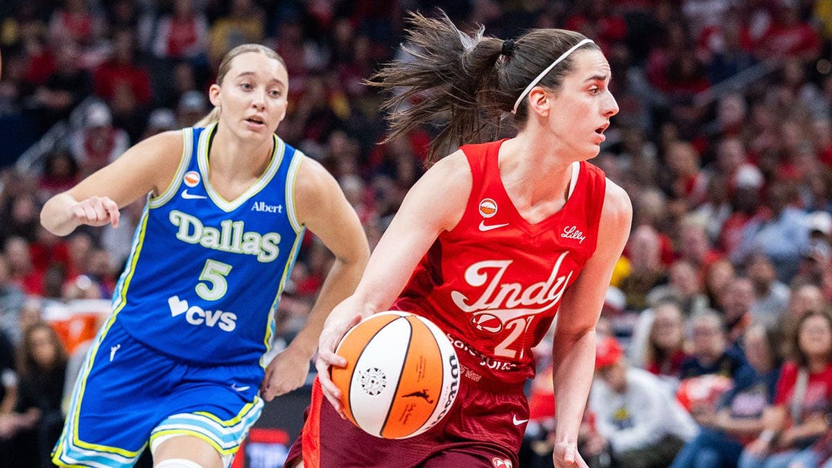 Indiana Fever guard Caitlin Clark dribbling basketball defended by Dallas Wings guard Paige Bueckers