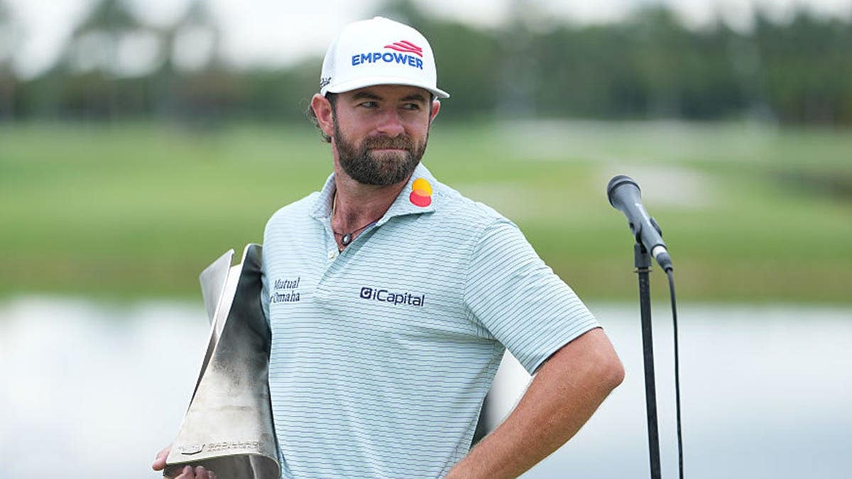 cameron young holding the cadillac championship trophy