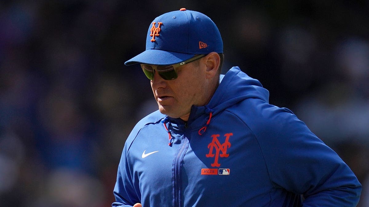 New York Mets manager Carlos Mendoza walking back to dugout during baseball game