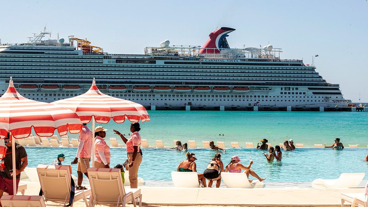 A Carnival Cruise ship sails by in a blue ocean.