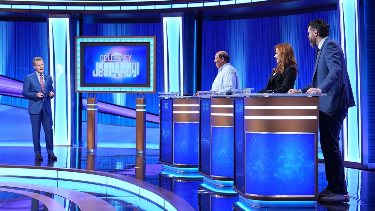Brian Baumgartner, Lisa Ann Walter, and Timothy Simons seated on Celebrity Jeopardy set