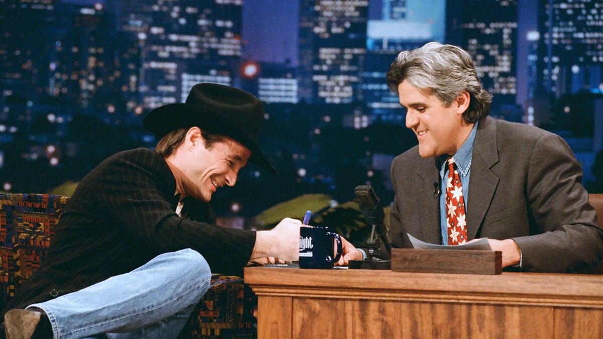 Musical guest Clint Black talking with host Jay Leno on The Tonight Show set.