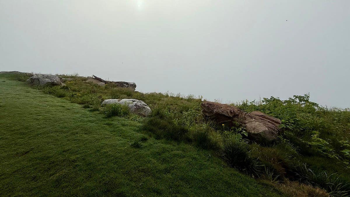 uma nuvem densa fica à beira de um penhasco na montanha