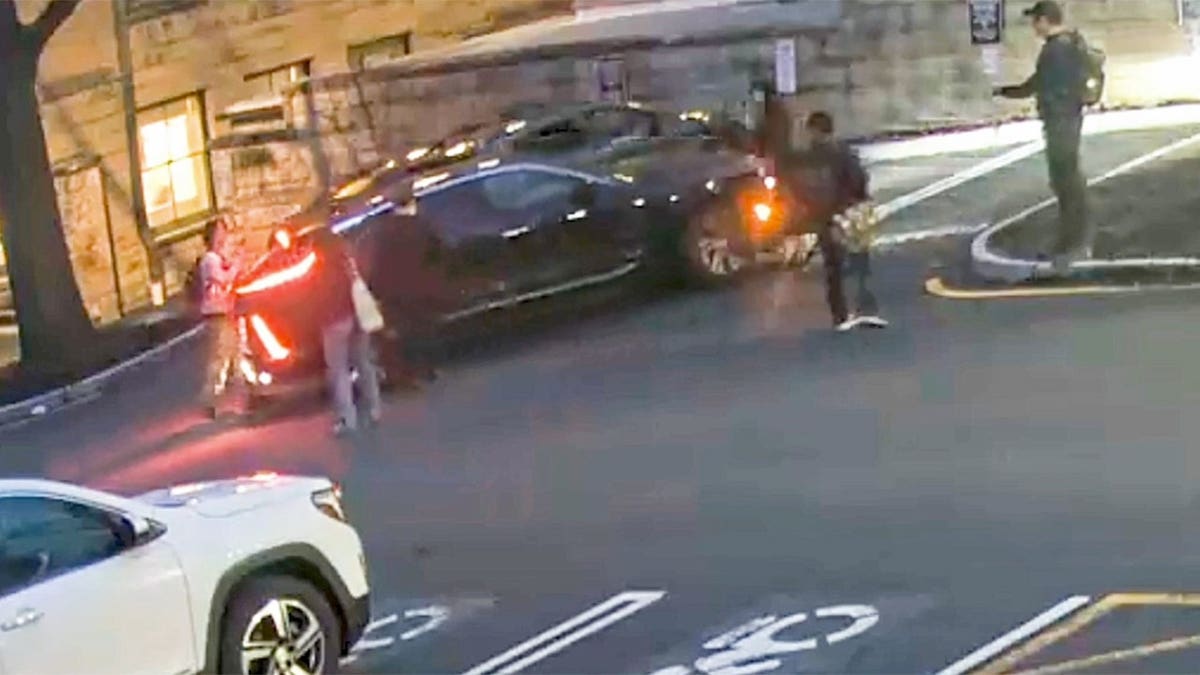 President Michael Kotlikoff backing vehicle into group in campus parking lot
