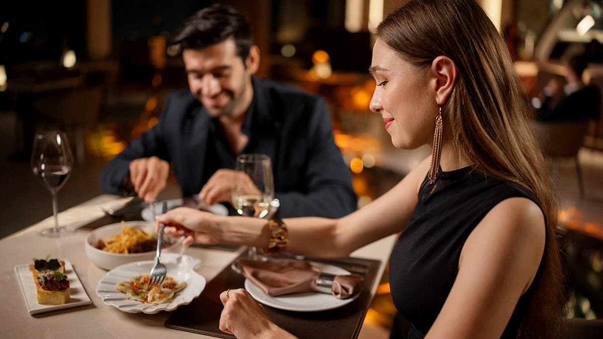 A couple eats dinner together.