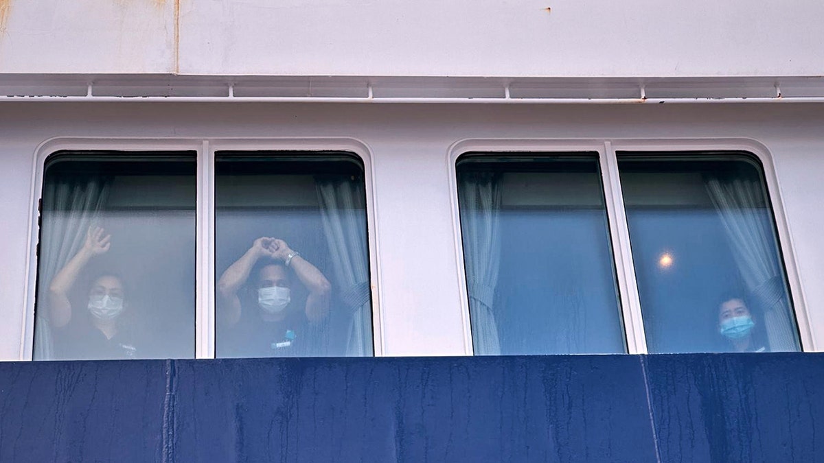 Passengers watching others disembarking from the hantavirus-stricken MV Hondius cruise ship at port