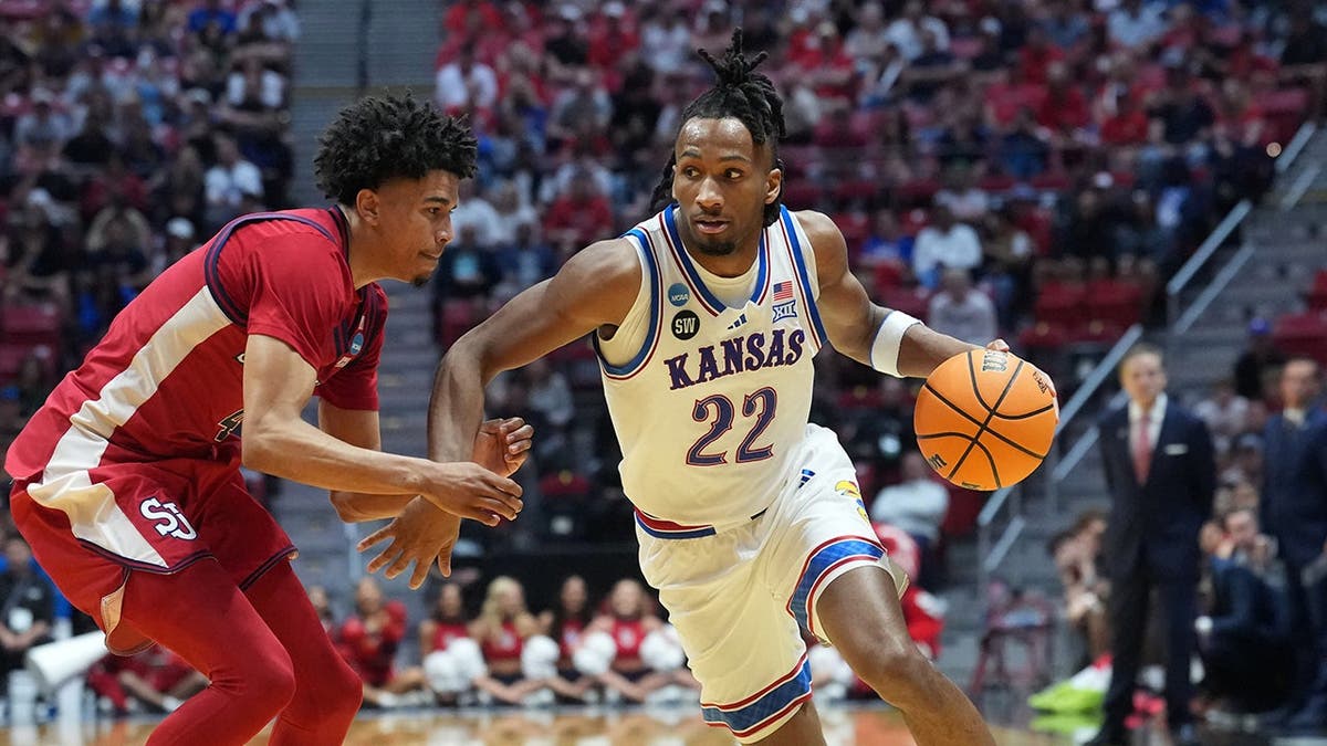 Kansas Jayhawks guard Darryn Peterson dribbling basketball against St. John's Red Storm guard Oziyah Sellers