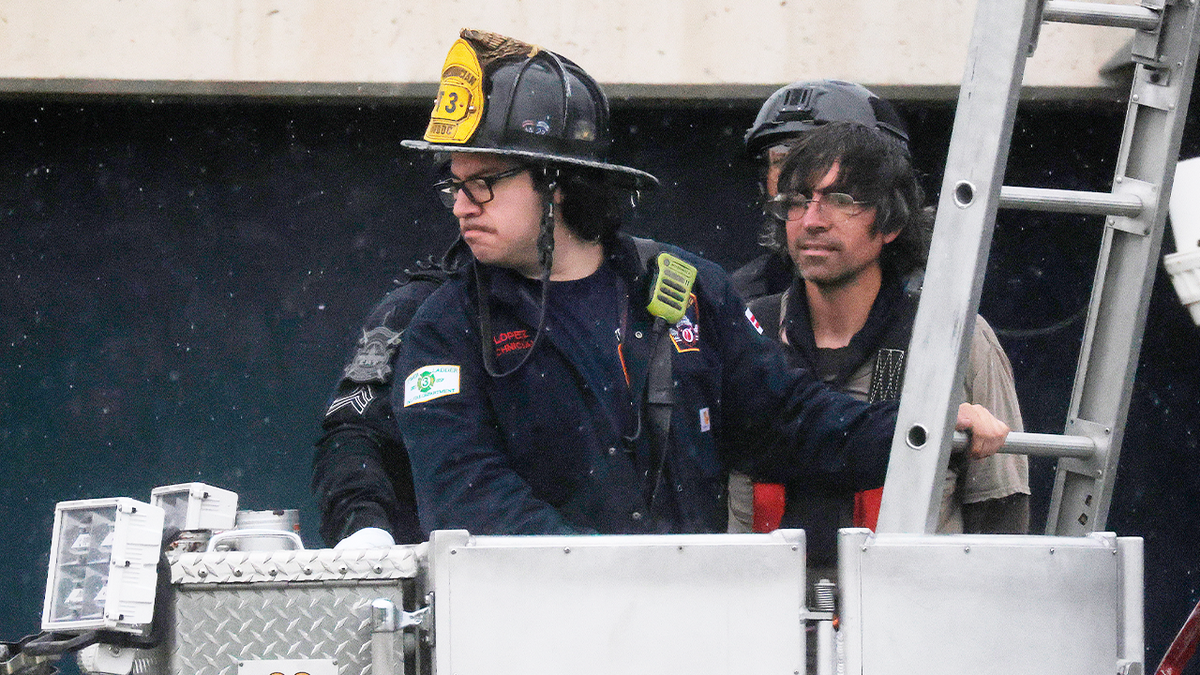 Protester Guido Reichstadter comes down from atop the Frederick Douglass Memorial Bridge