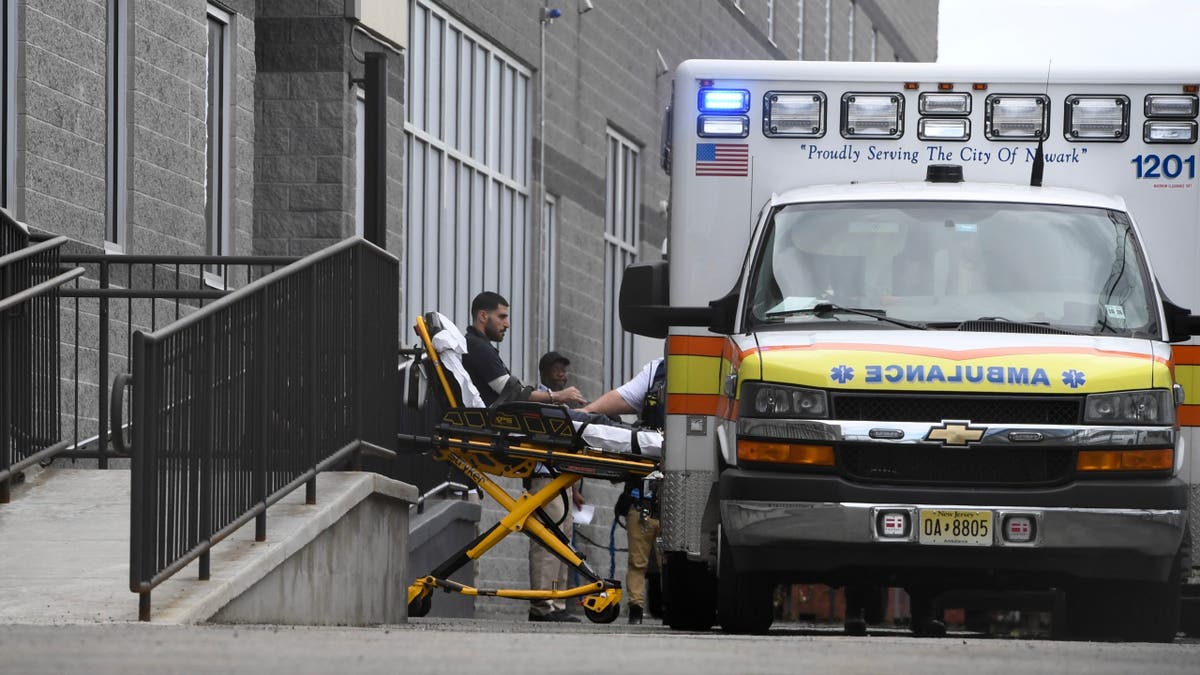 Están sacando a una persona del Delaney Hall para subirla a una ambulancia