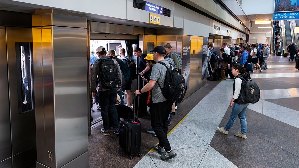 Travelers boarding the Automated Guideway Transit System people mover at Denver International Airport.