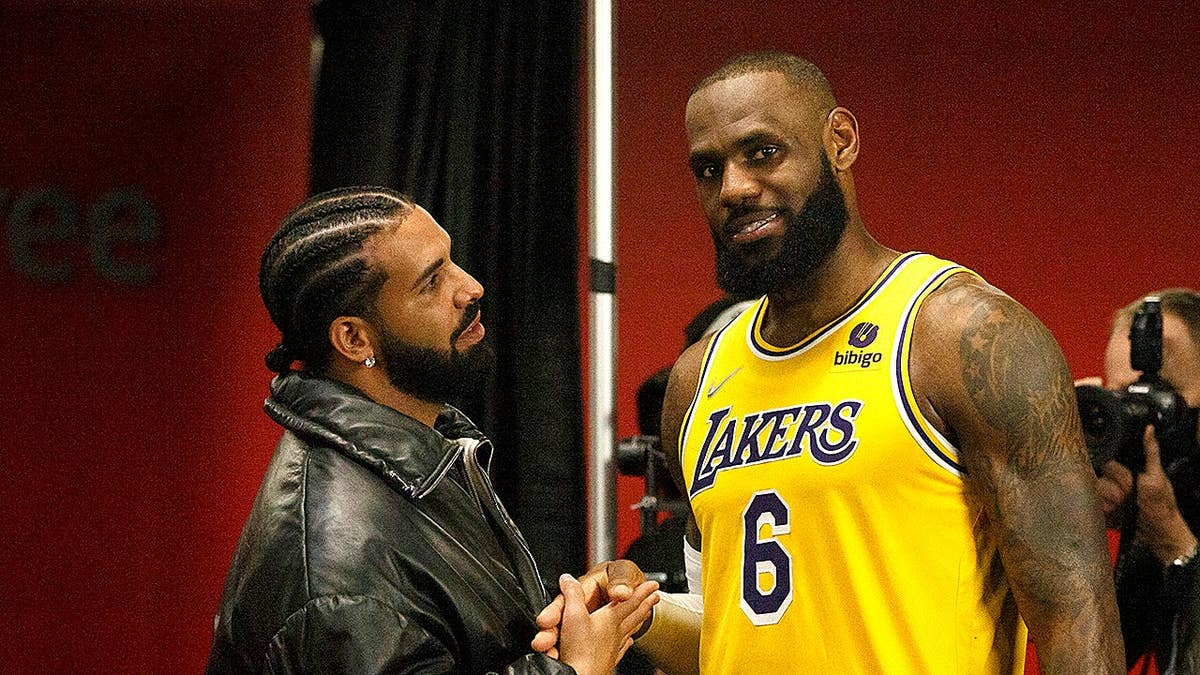 Drake and LeBron James talking at Scotiabank Arena during an NBA game.