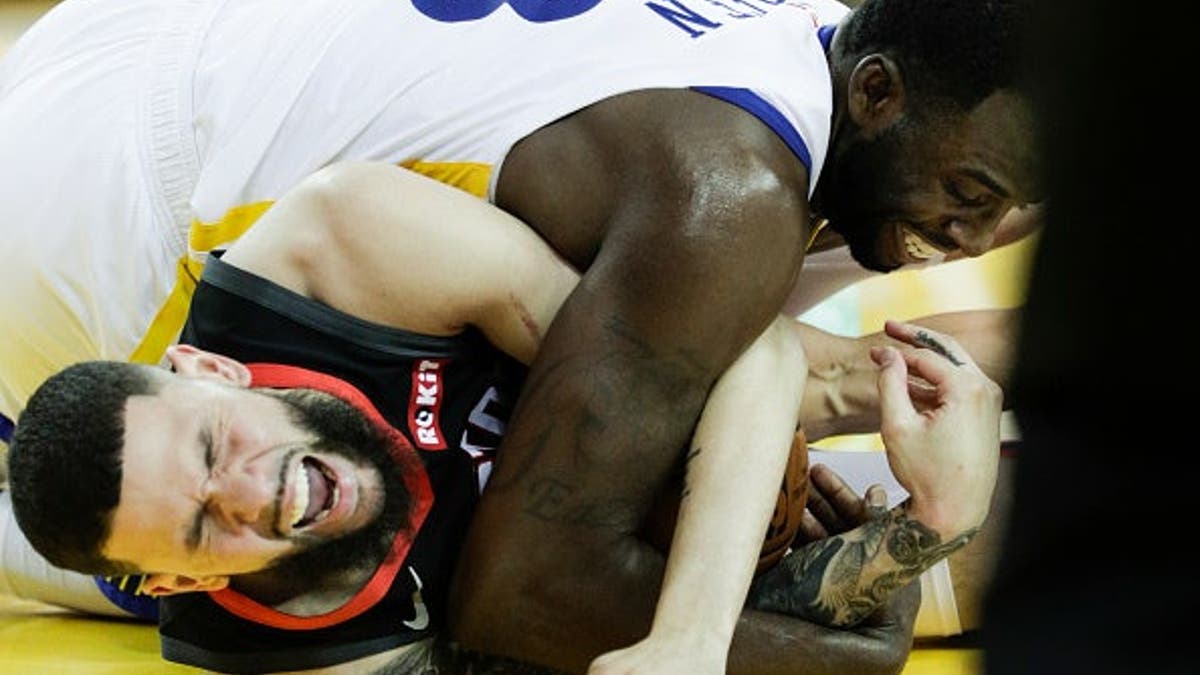 Draymond Green and Austin Rivers fighting for the basketball during a game at Oracle Arena