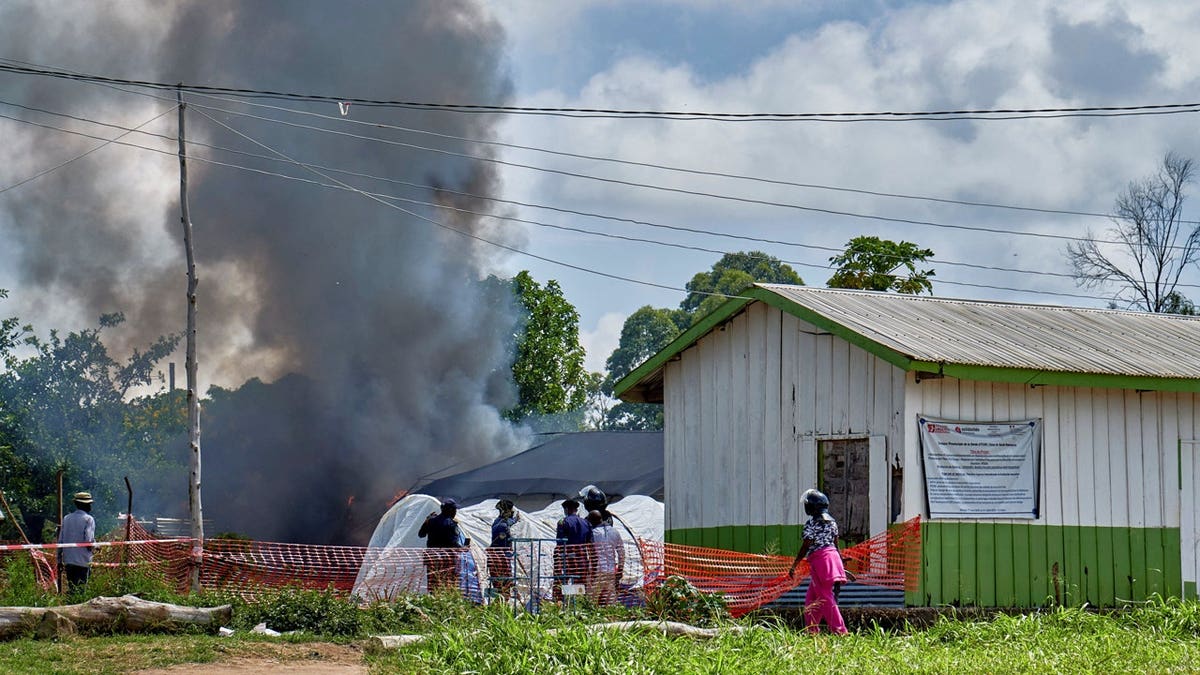 Congolese constabulary  unit   and civilians basal   adjacent   the burning Ebola attraction    center