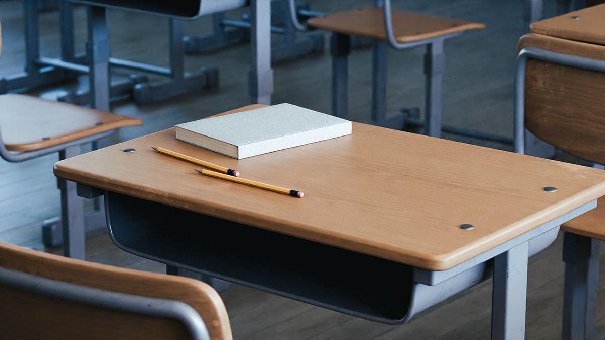 An empty classroom with desks and chairs arranged neatly.