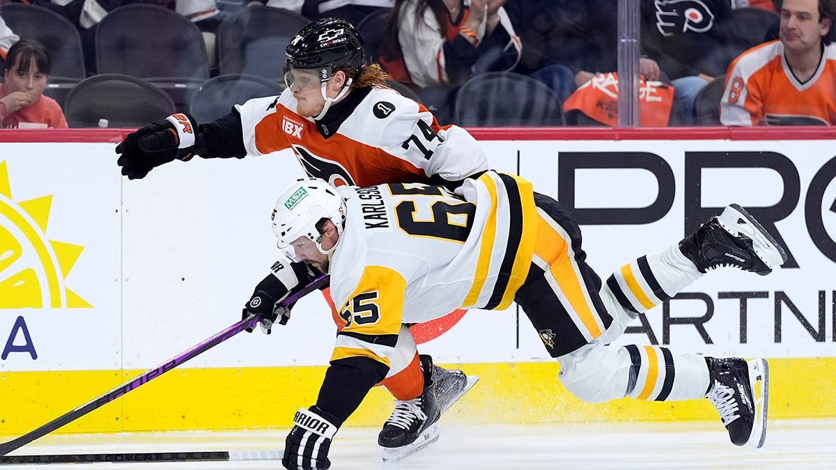 Erik Karlsson dei Pittsburgh Penguins e Owen Tippett dei Philadelphia Flyers inseguono il disco sulla pista di pattinaggio