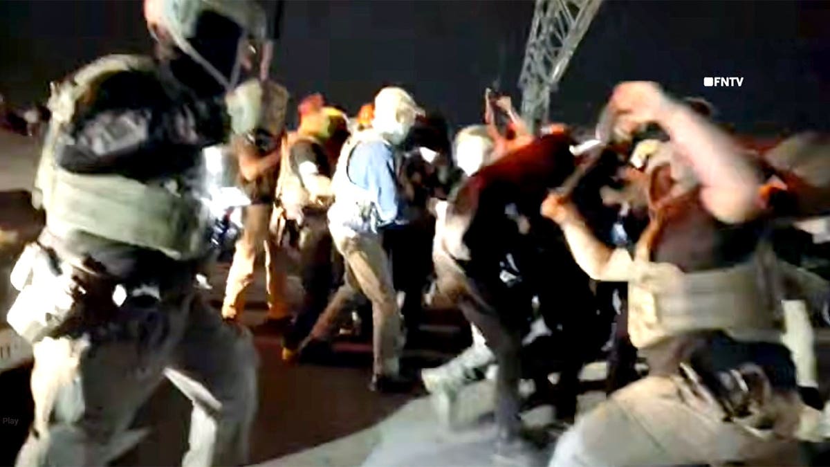 Federal agents swinging batons at anti-ICE agitators