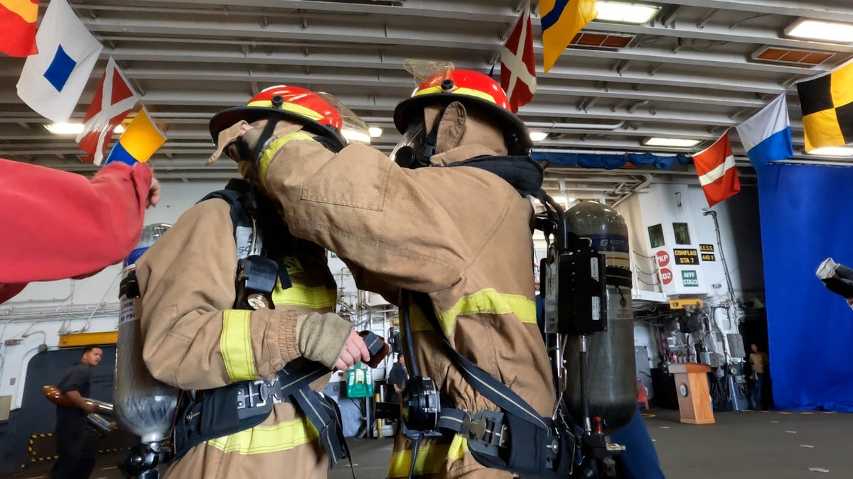 FOX reporter and sailors participate in a firefighting demonstration aboard the USS Kearsarge in New Orleans.