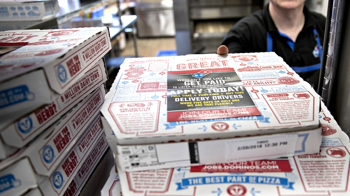 Male employee picking up Domino's boxes