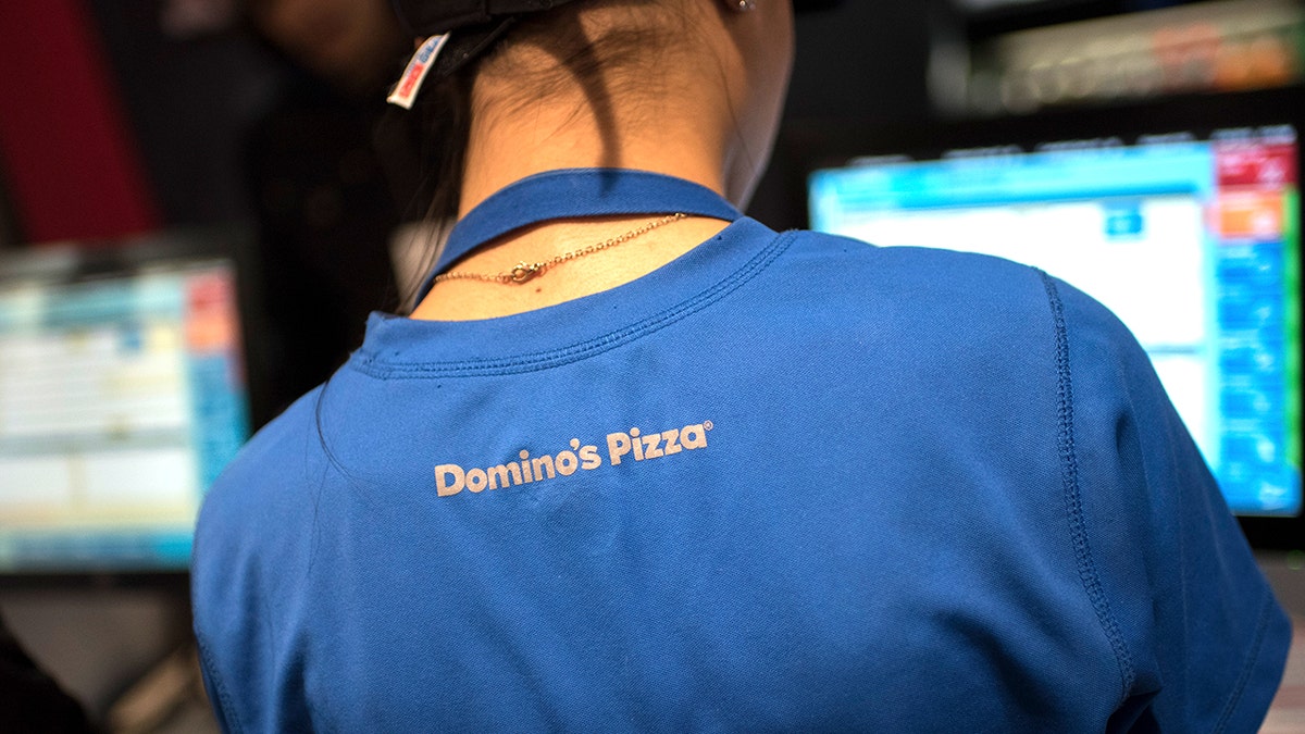 A female Domino's employee looking at a screen