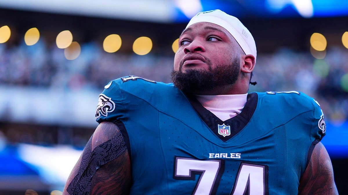 Fred Johnson, do Philadelphia Eagles, parado na linha lateral durante o hino nacional