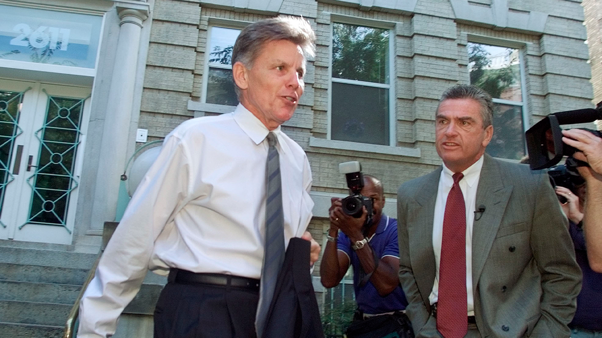 Gary condit carries his suit jacket as he walks by reporters outside his former Washington apartment following the disappearance of Chandra Levy in 2001