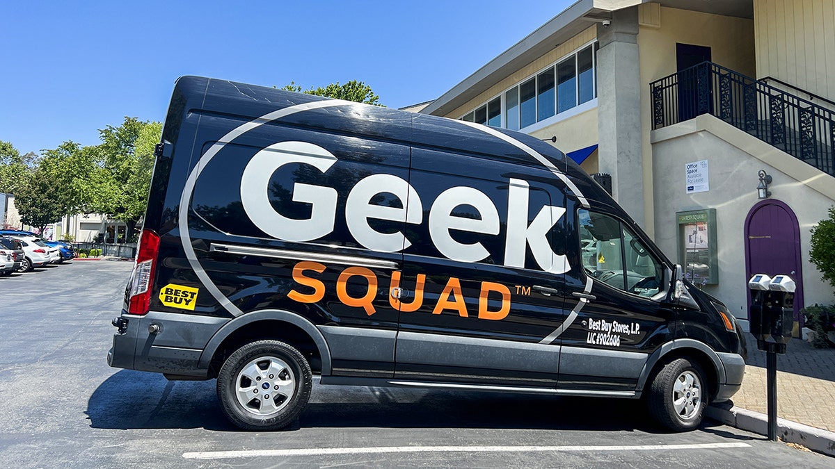 Geek Squad van parked in a parking lot.
