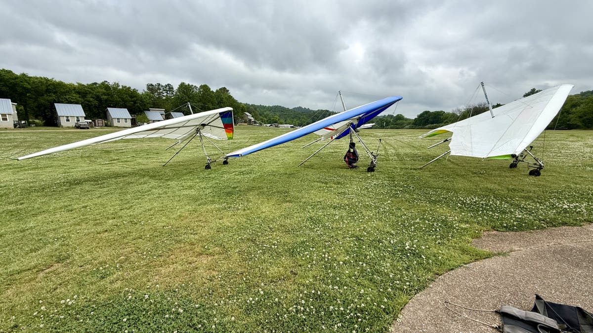 Três asas-delta alinhadas em um campo no Lookout Mountain Flight Park