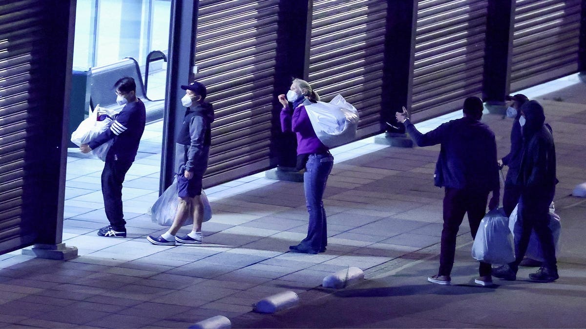 masked people line up to enter warehouse