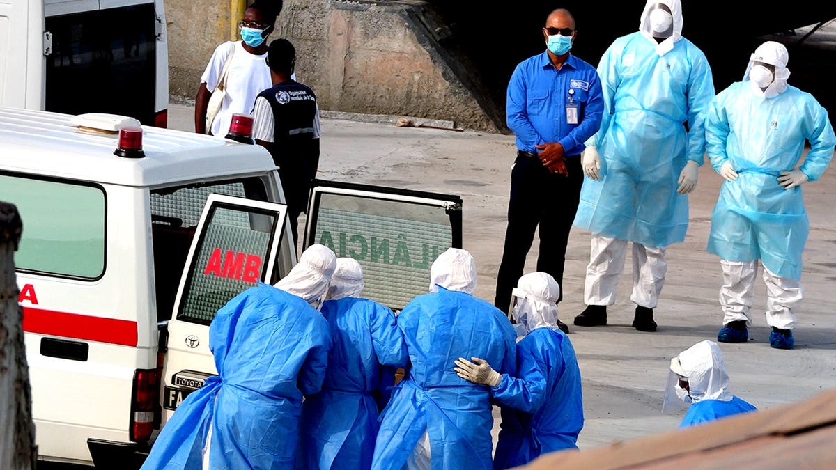 Health workers in protective gear evacuate patients from MV Hondius cruise ship into ambulance at port