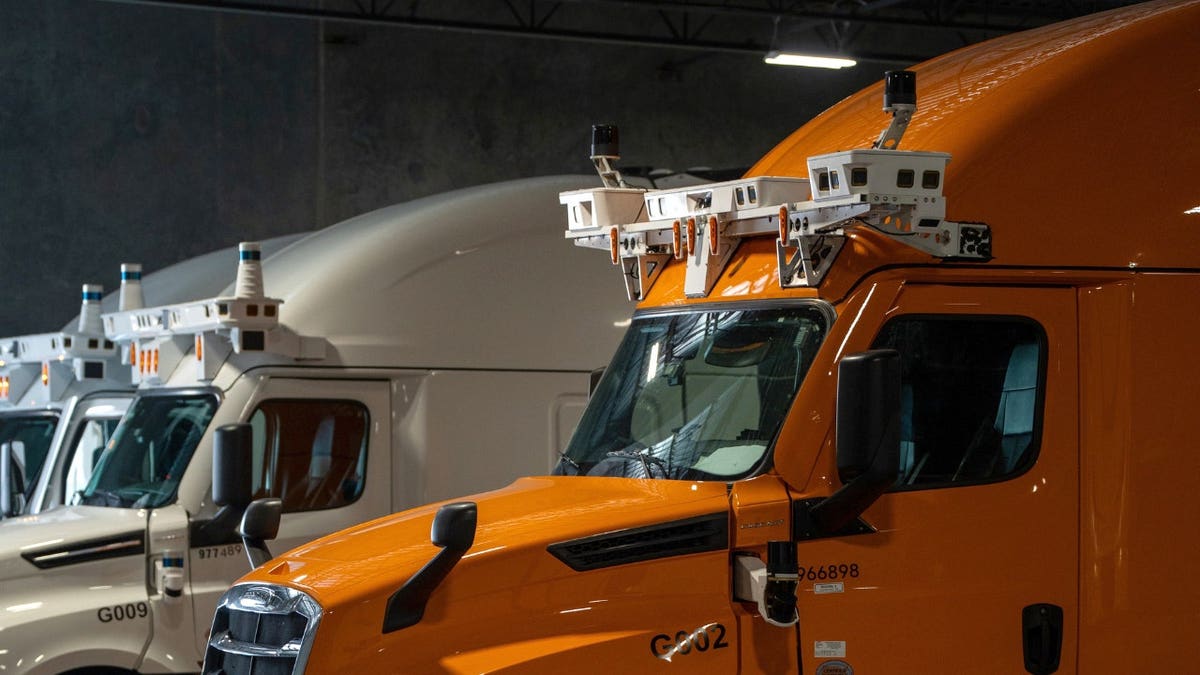 Autonomous trucks are parked next to each other.
