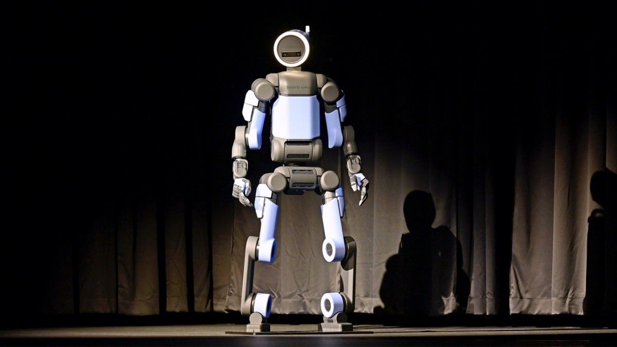 A Hyundai robot stands connected a stage.