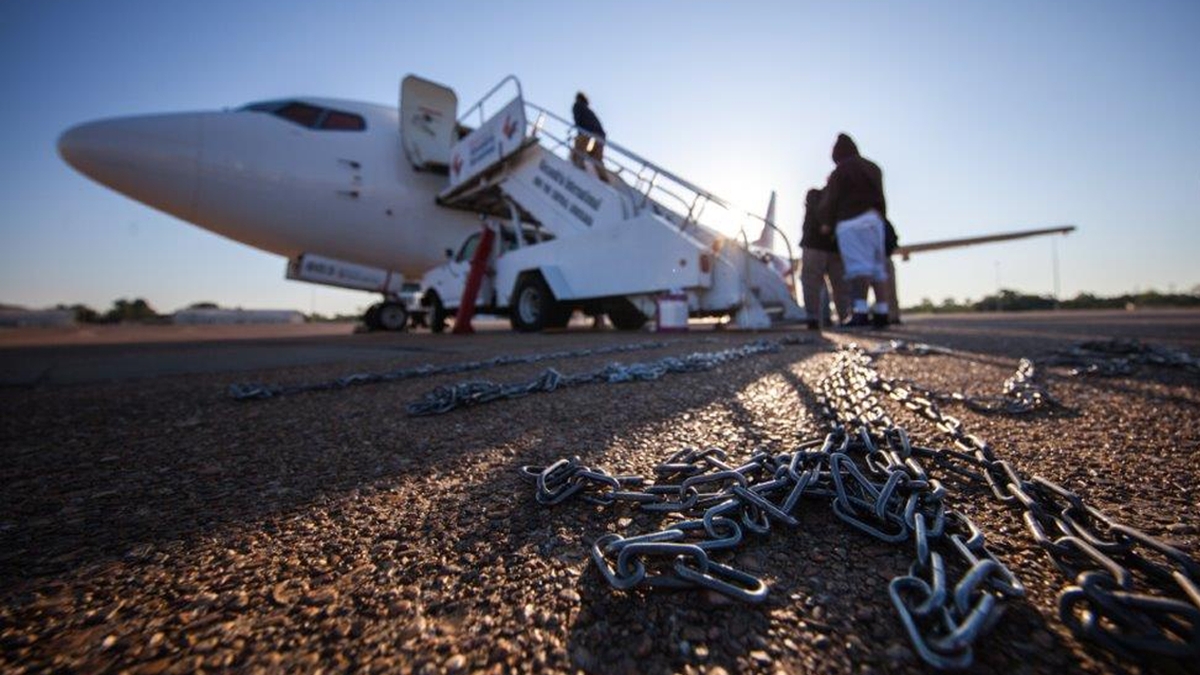 An ICE plane being boarded by deported individuals