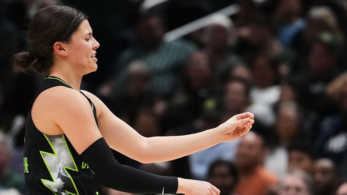 Seattle Storm guard Jade Melbourne holding half of her lost tooth during a basketball game.