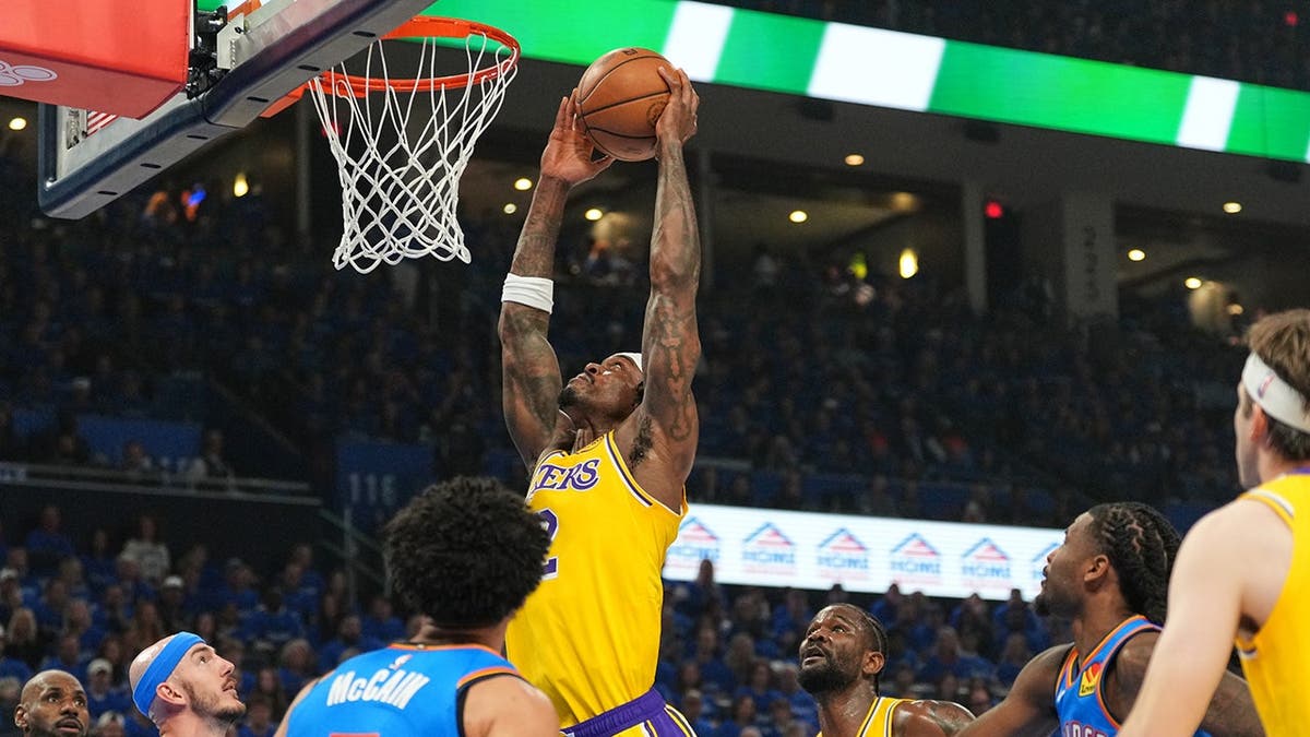 Los Angeles Lakers forward Jarred Vanderbilt shooting as Oklahoma City Thunder defenders Jared McCain and Alex Caruso defend