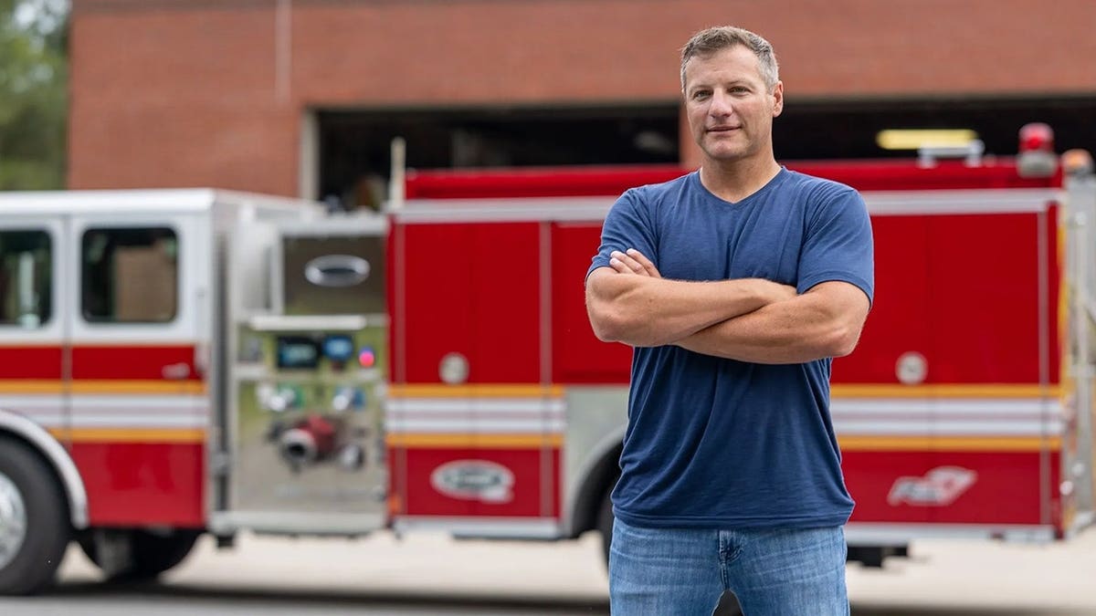 firefighter jason cerrano in front of a fire truck
