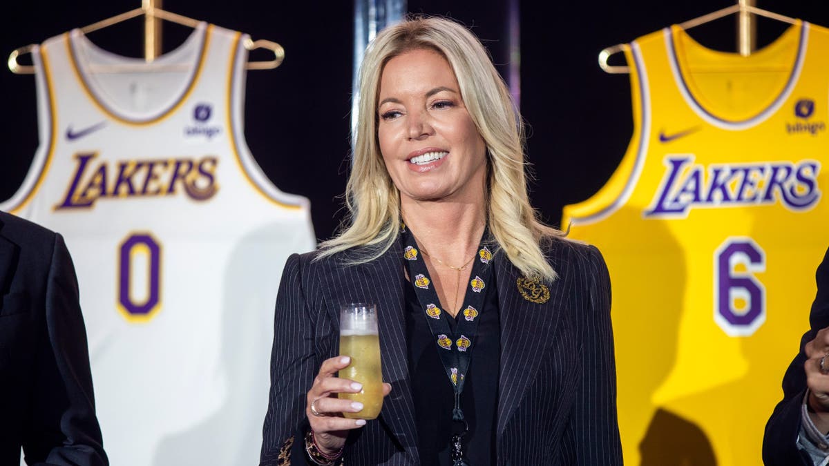 Jeanie Buss holding a new Los Angeles Lakers jersey at a training center
